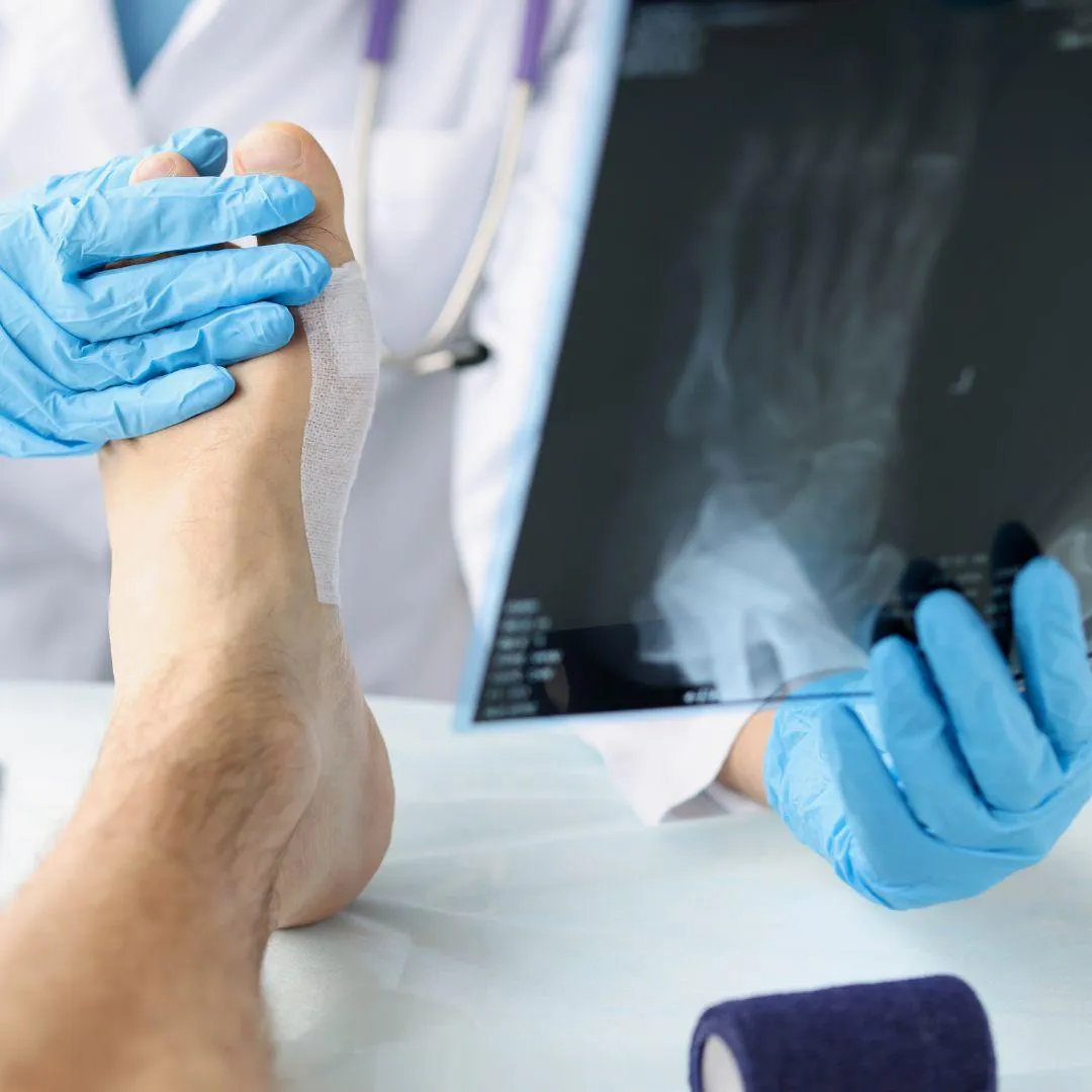 Board-certified podiatrist Dr. Hansen examining patient's foot in professional medical clinic setting with diagnostic equipment visible in background