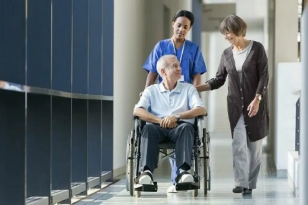 man leaving hospital with caregiver