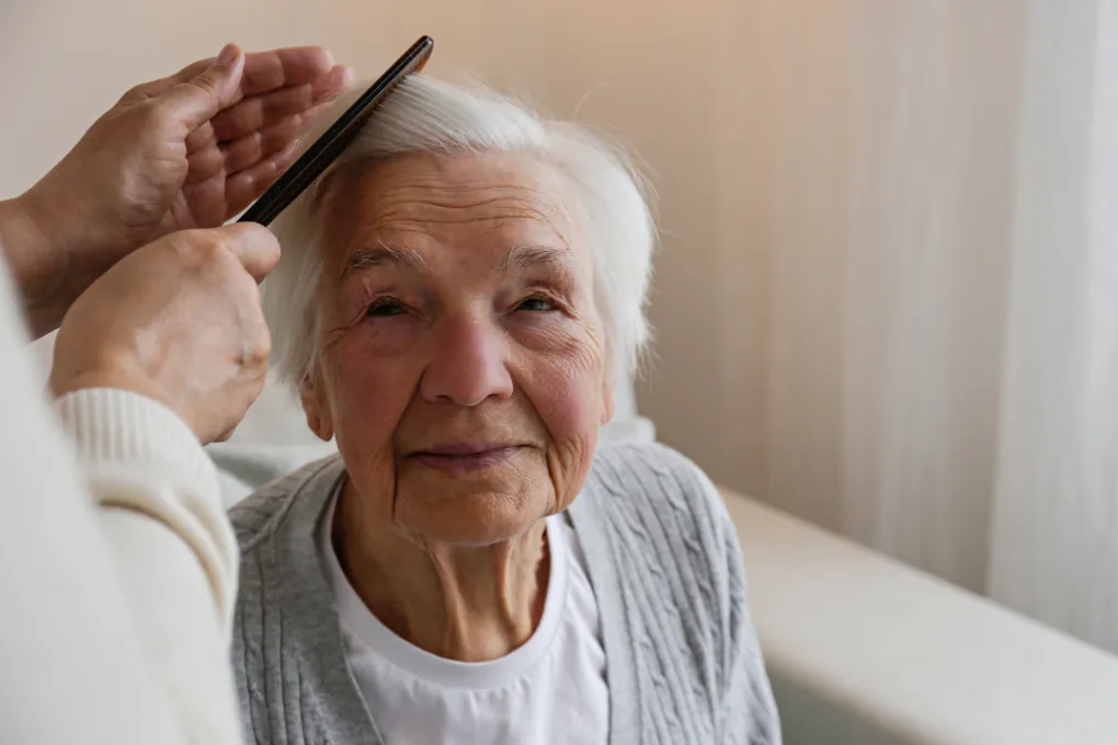 Caregiver providing personal care to elderly woman