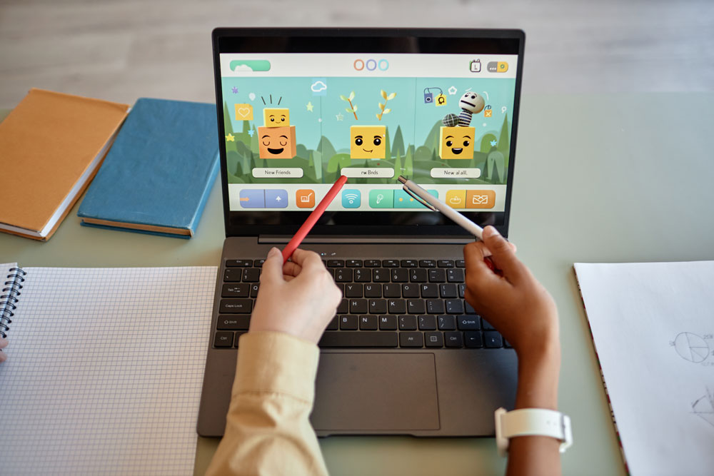 Students trying video game on laptop