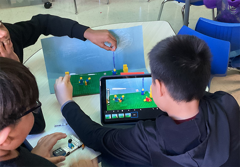 Students trying video game on laptop