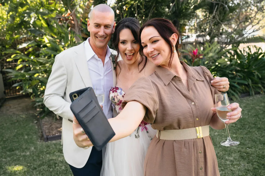 Wedding celebrant taking photo with happy newlyweds