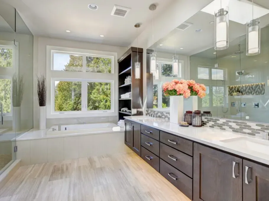 Renovated Vista California bathroom with modern fixtures, glass shower, marble counters, polished tiles, and natural light