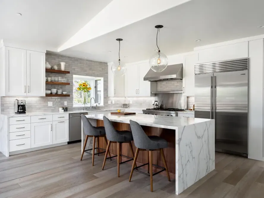 Modern remodeled Vista California kitchen with quartz countertops, white cabinets, wooden island, stainless steel appliances, hardwood floors, and natural light