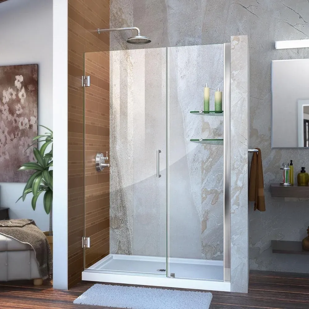 Freshly installed frameless glass shower door with chrome hinges in a modern, minimalistic bathroom with marble walls and natural lighting