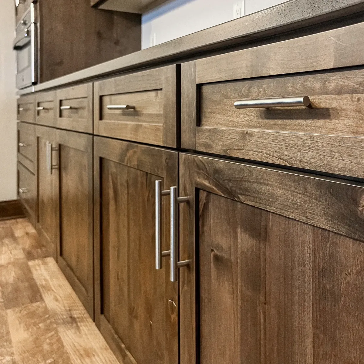 Modern kitchen with polished wooden cabinets and brushed nickel handles in Vista California, highlighting craftsmanship and style