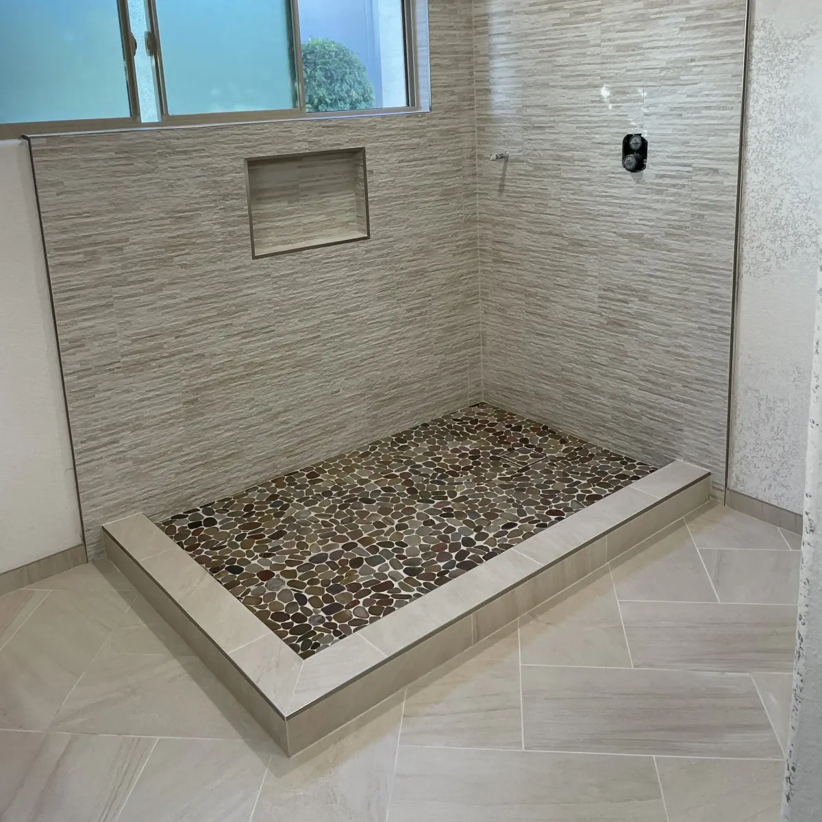 Finished natural stone tile outdoor patio in Vista California with lush greenery, scenic hills, and stylish seating