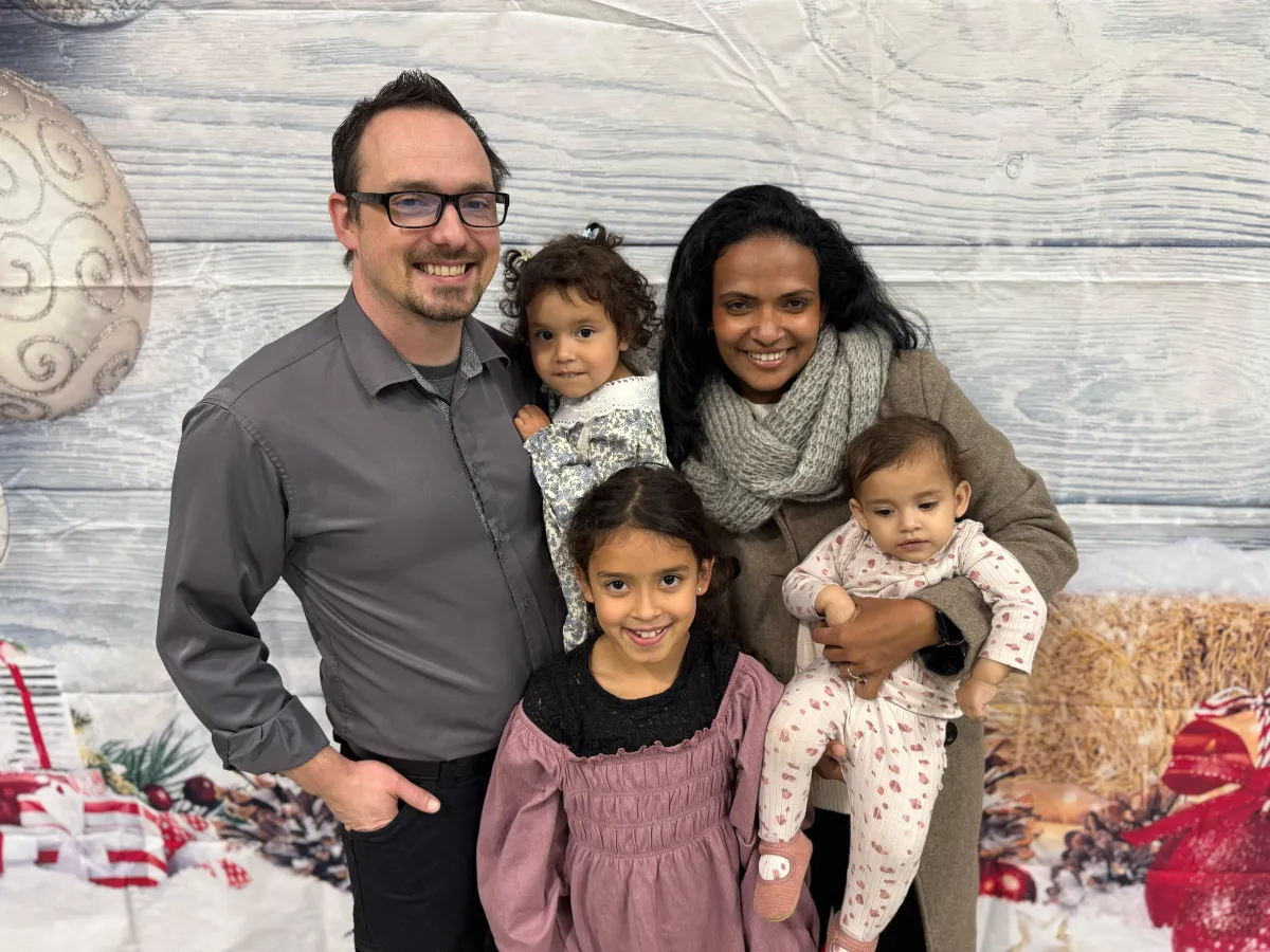 Founder Jesse Lowe smiling with his daughters outside Gymnastics Redefined, embodying the mission of building confidence and life skills in girls.