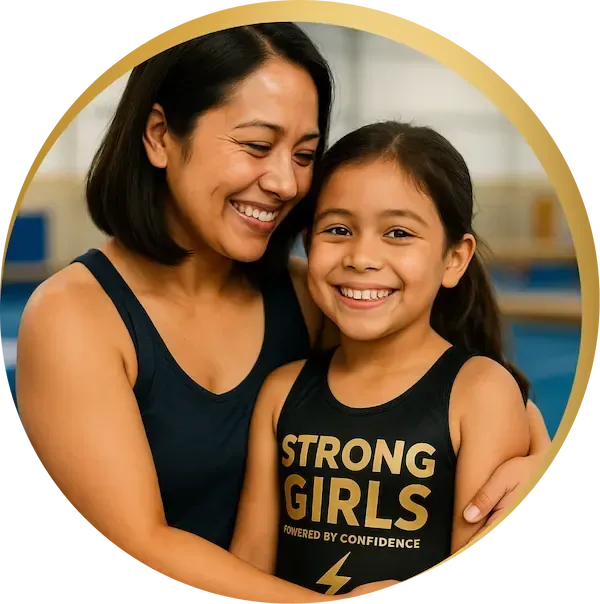 Two young girls laughing together in StrongGirls leotards at a bright gym, building confidence and joy