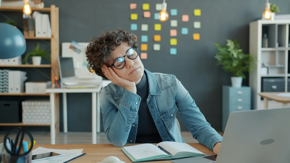 Professional woman at desk overwhelmed by ADHD racing thoughts and cognitive overload at night