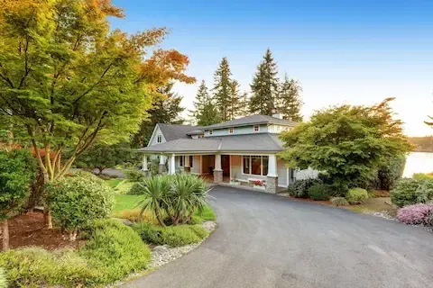 Spacious craftsman-style home with a freshly paved concrete driveway in a lakeside neighborhood