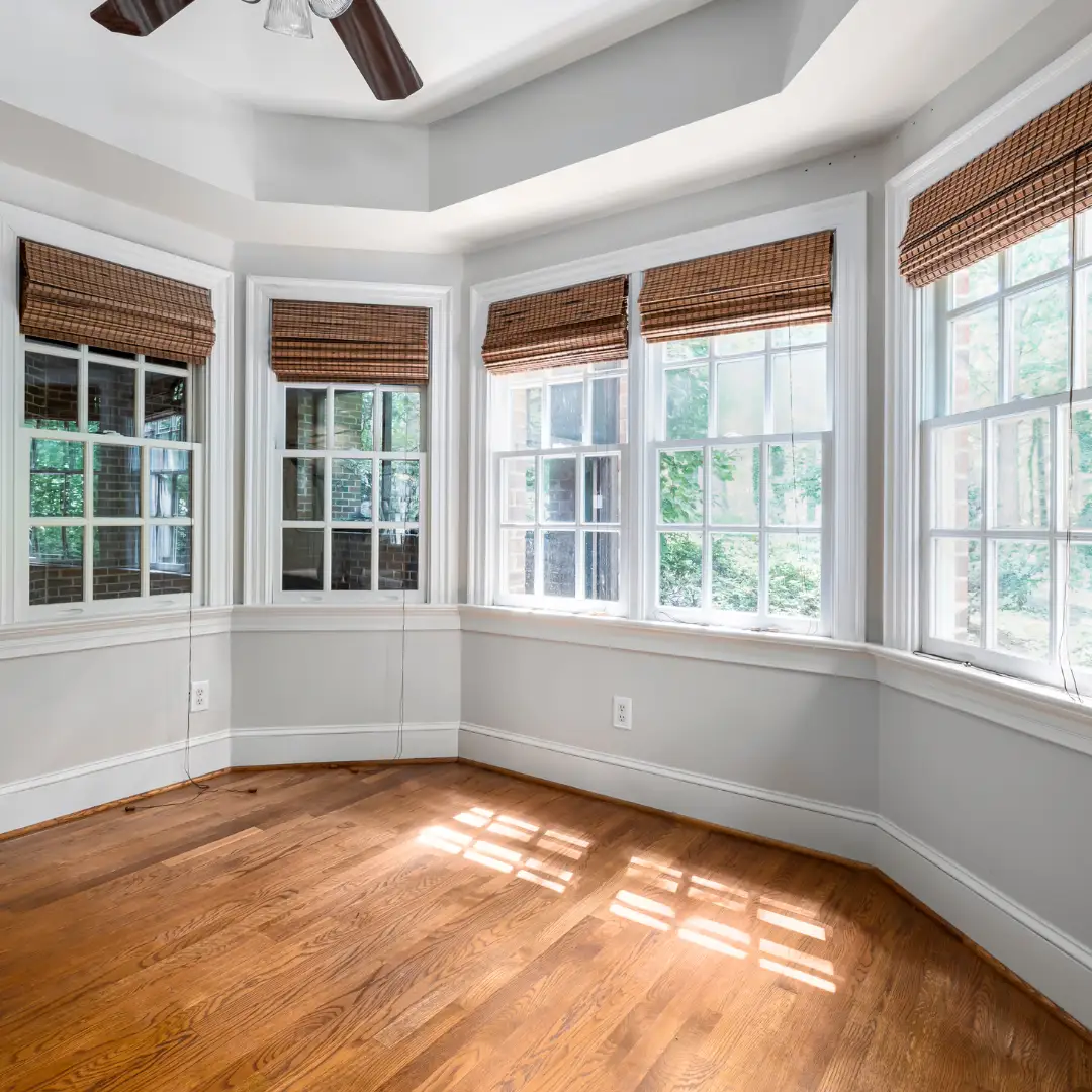 Bay windows in a bright room with hardwood flooring