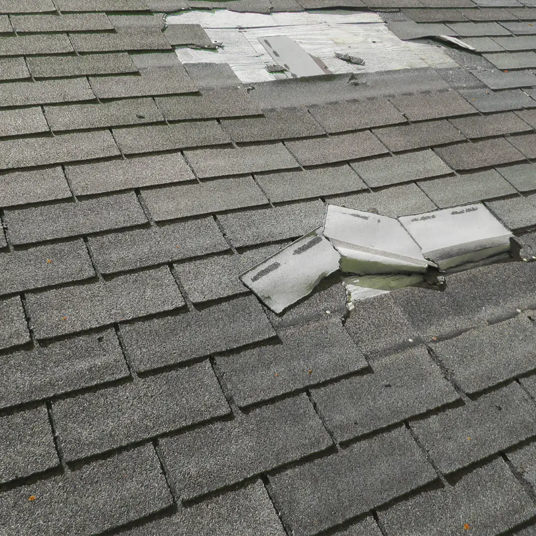 Damaged shingles exposing roof underlayment