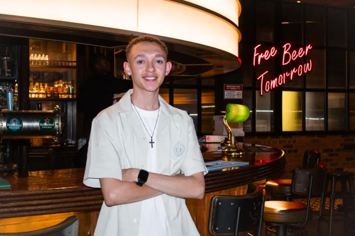 A professional marketing consultant in business attire, smiling and speaking on a headset in a bright, modern office with subtle branding and a world map.