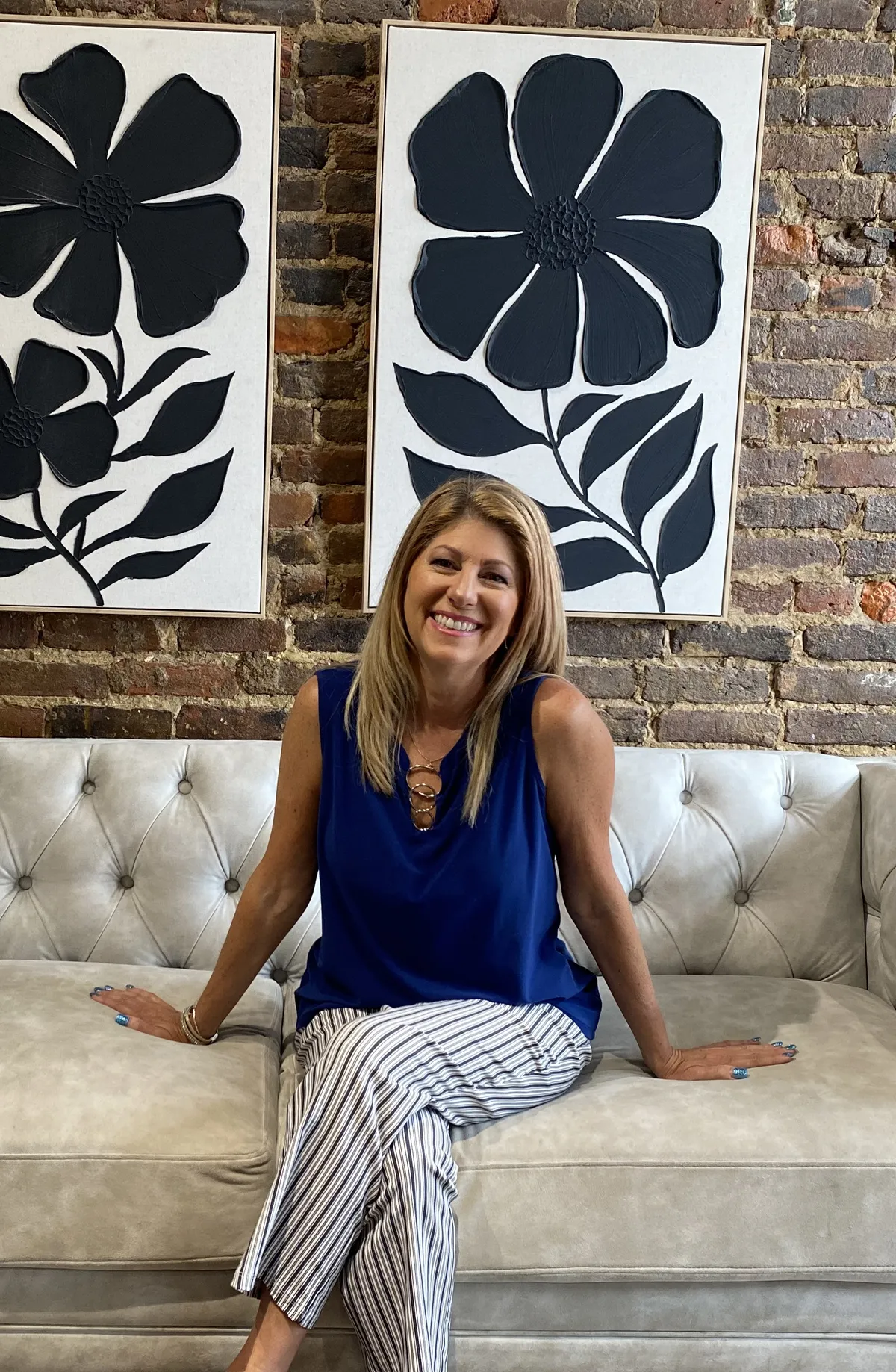 Sue Bonzell, business coach and media strategist, smiling warmly in a bright modern studio setting