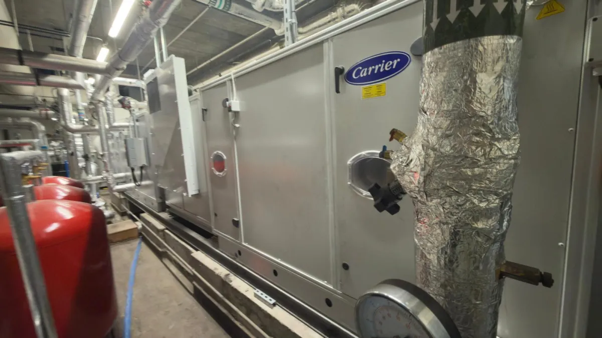 Service image showing an outdoor heat pump unit and technician, emphasising low-carbon installations