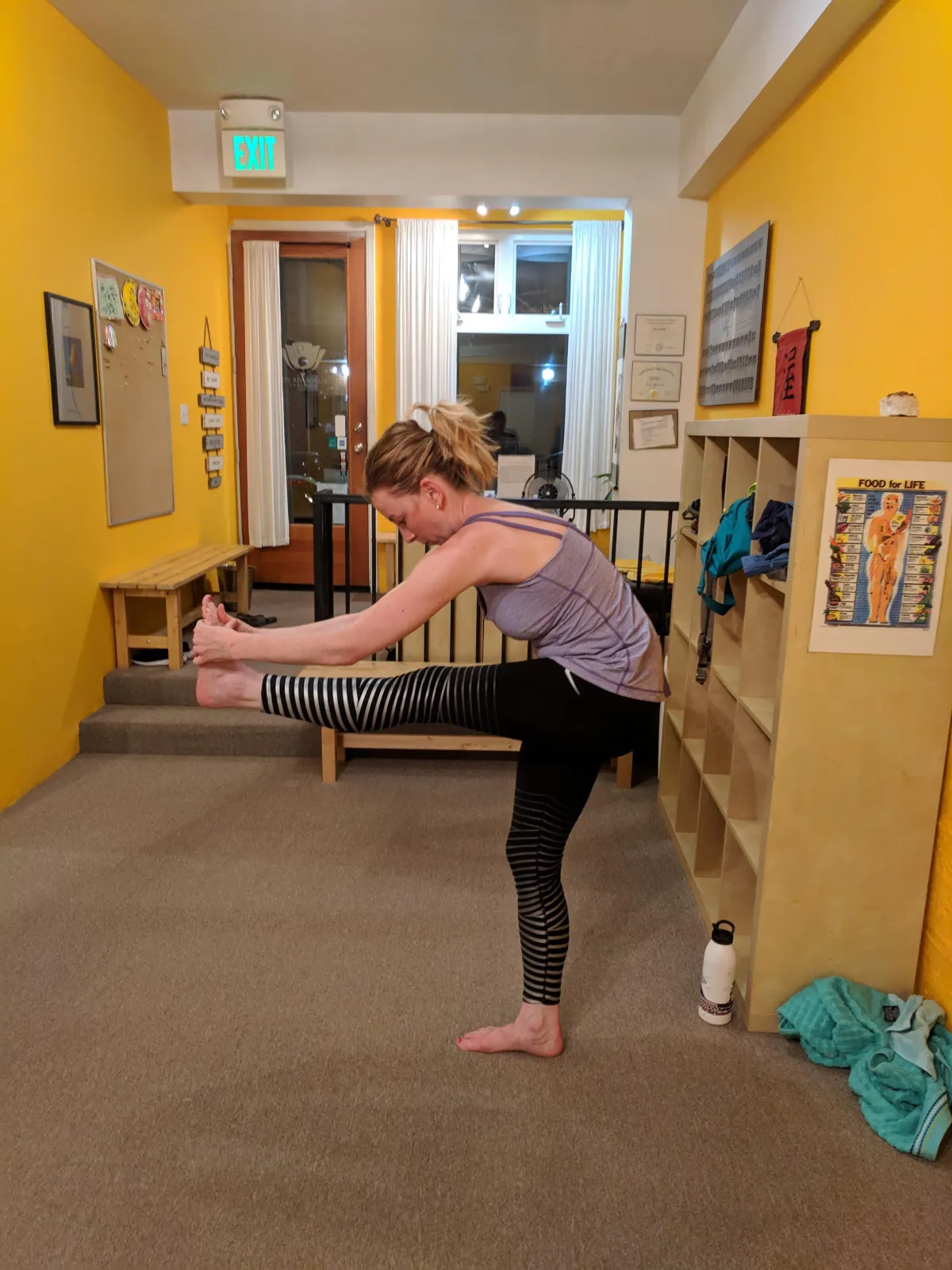 Reformer carriage with instructor adjusting client, warm studio tones