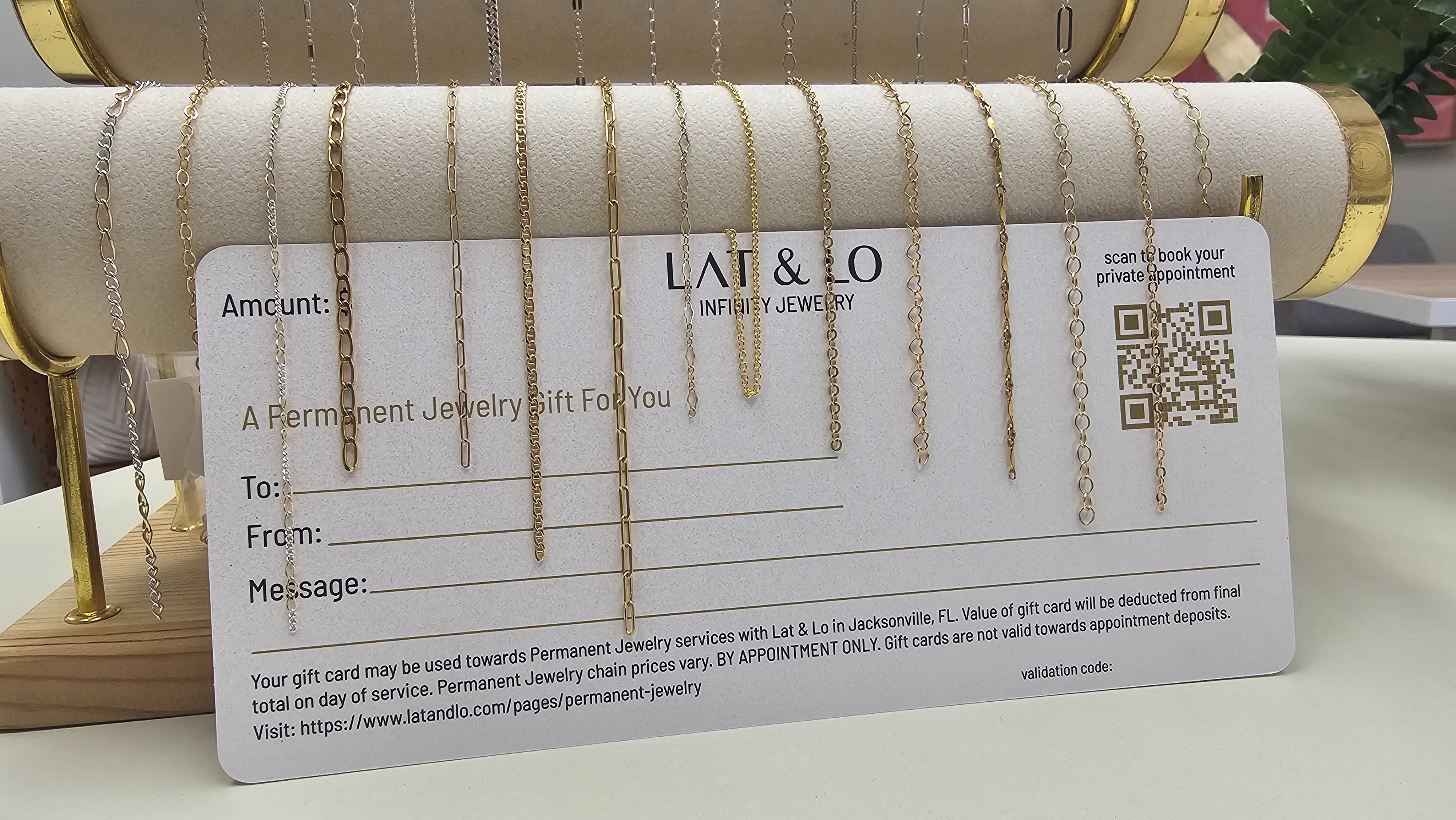 A close-up of hands exchanging a beautifully designed Infinity Jewelry gift card, with soft focus on the elegant card and subtle gold foil accents. The background is a gentle blur of pastel tones, suggesting anticipation and delight.