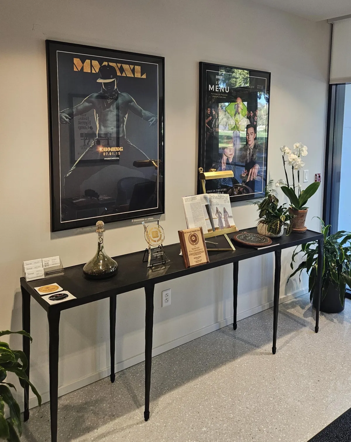 Custom framed movie posters and entertainment artwork displayed in a modern commercial interior by Friedman’s Framing in Savannah, GA