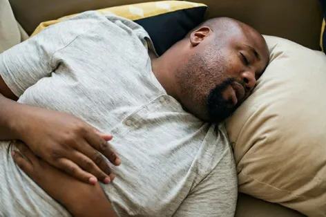 a man sitting on a couch wearing a hat