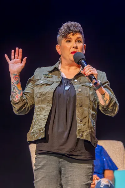 Women holding a microphone and her hand up