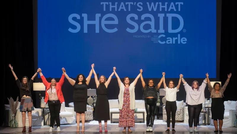 Group of women holding hands on-stage preparing to bow