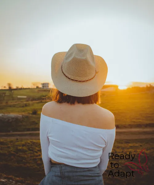 Farm Woman Looking across paddock at sunset