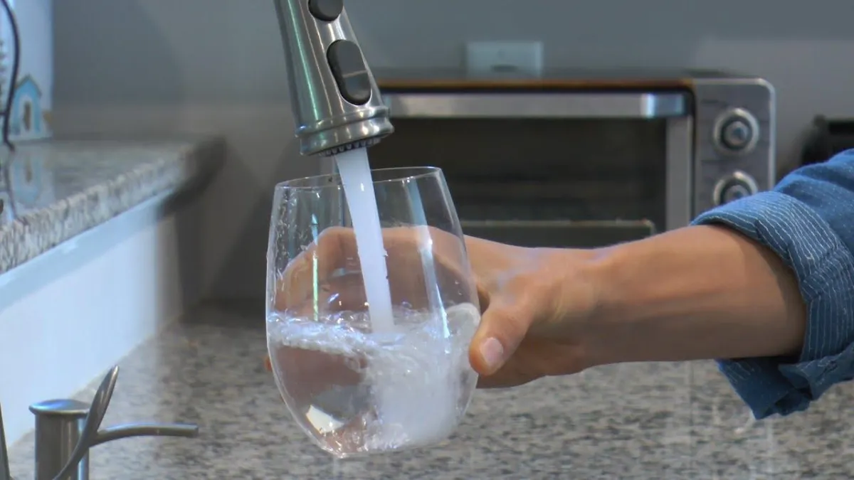 clear glass mug beside white and blue electric toothbrush