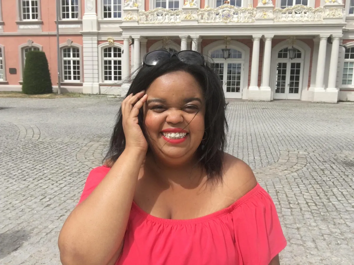 Jasmin Bryan Smiling in Front of pink castle in germany