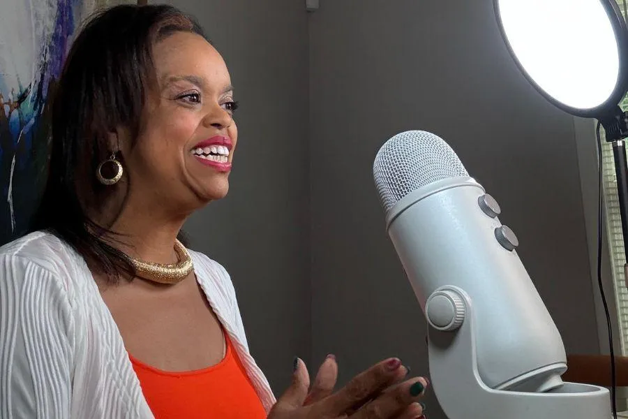 Jasmin Bryant smiling in a white blouse with a hot air balloon in the background.