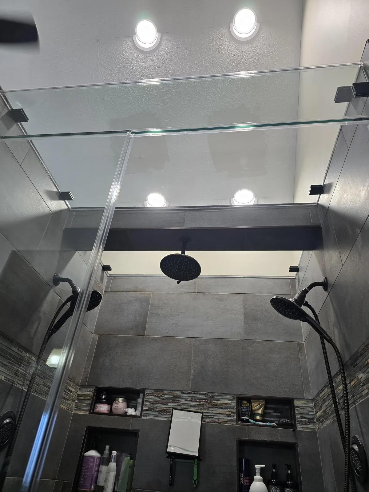 Frameless glass shower enclosure with transom panel and black hardware installed in Dayton, Ohio by RDB Glass