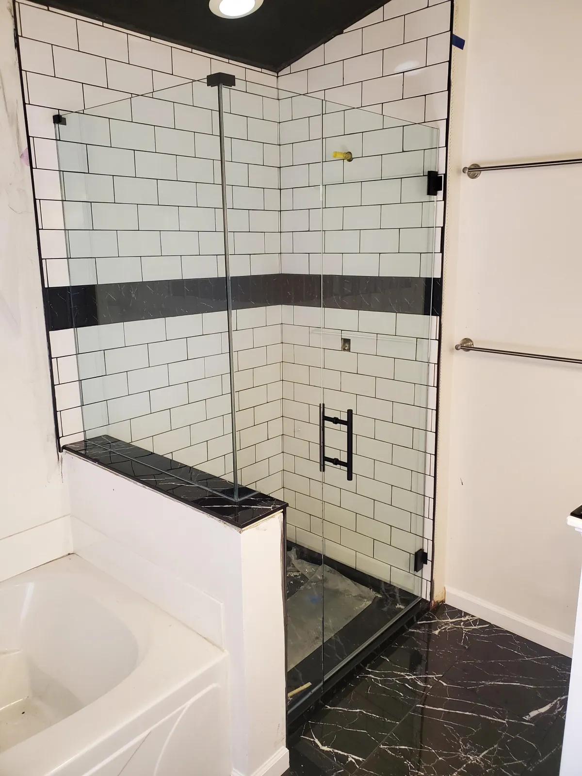 Custom frameless glass shower enclosure with hinged door and black hardware installed in Dayton, Ohio by RDB Glass