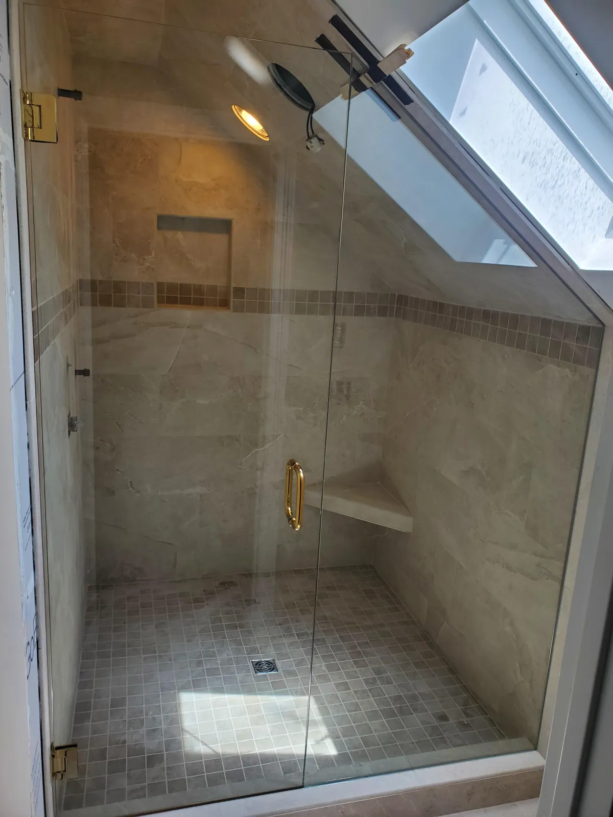 Custom frameless glass shower enclosure with hinged door under a sloped ceiling in Dayton, Ohio by RDB Glass