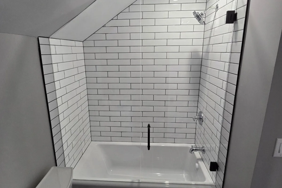 Modern bathroom featuring a frameless custom glass shower enclosure with white subway tile – RDB Glass shower installation Dayton, OH.