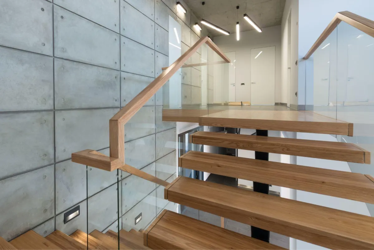 Contemporary indoor staircase with frameless glass railings and wooden steps, installed by RDB Glass – modern glass railing solutions for homes in Dayton, OH.