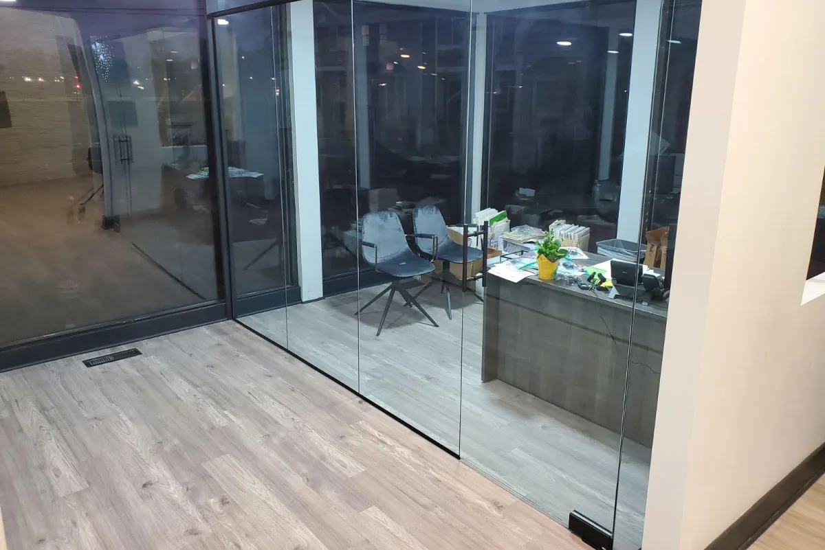 Frameless glass office partitions enclosing a modern meeting space with wood flooring, installed by RDB Glass in Dayton, OH.