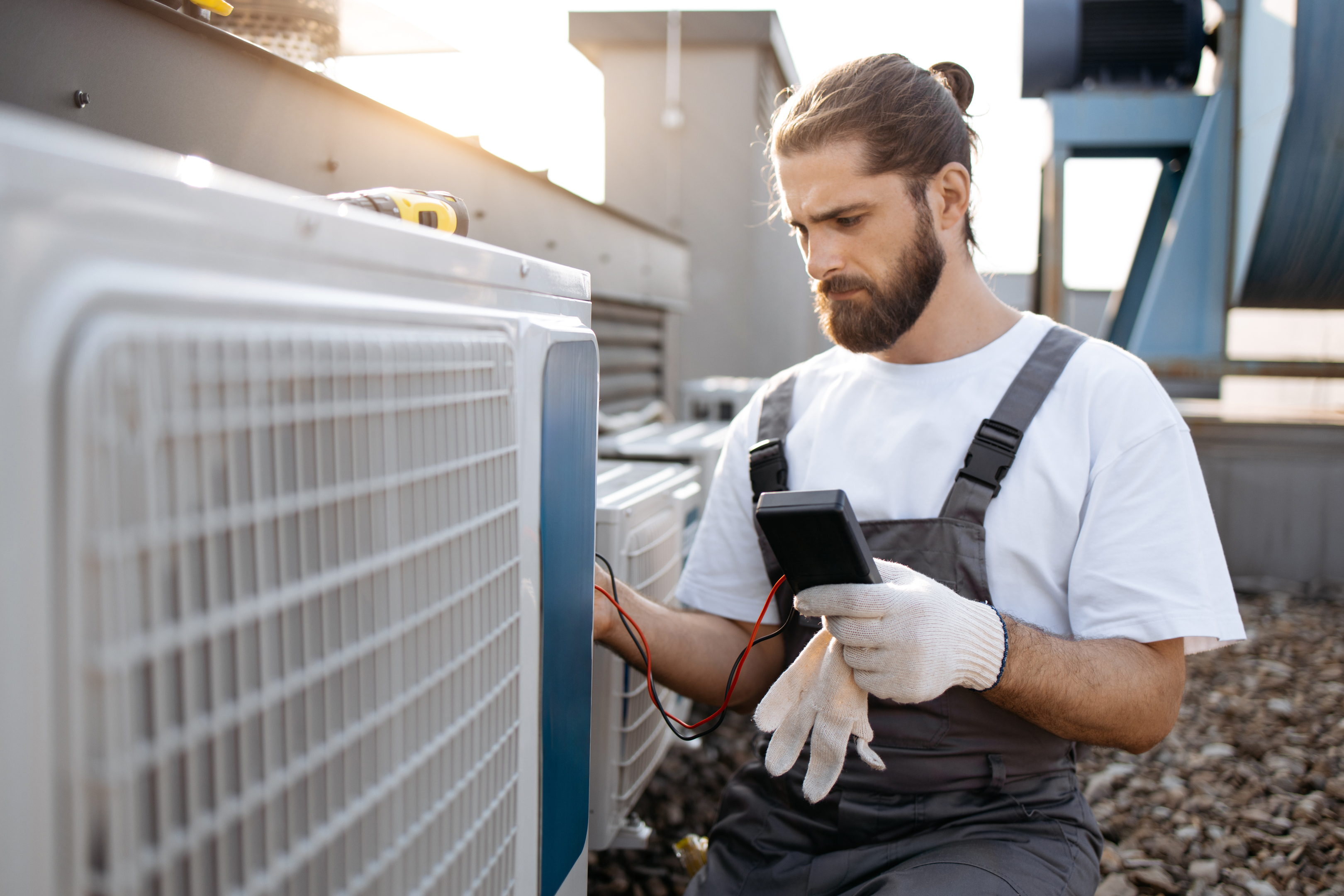 Licensed AC technician inspecting an outdoor unit to ensure proper AC installation and reliable system performance.