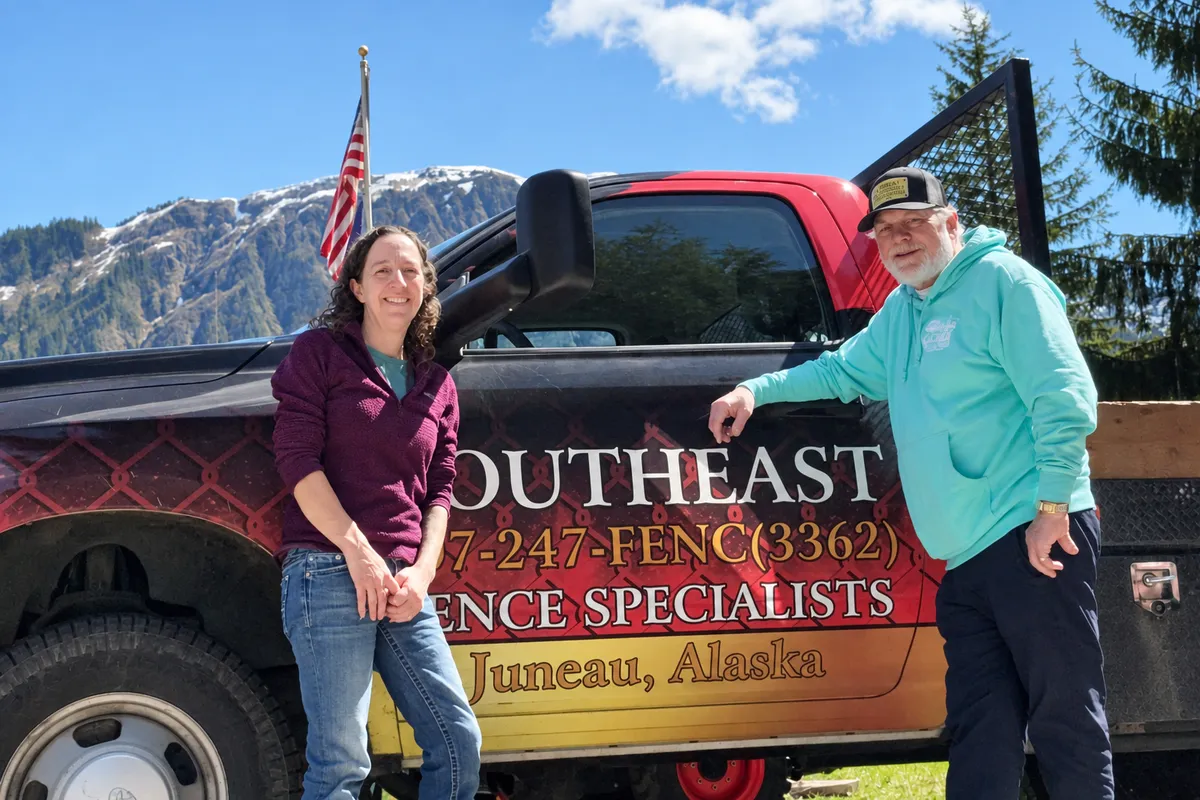 Julie and Spencer beside a Southeast Fence Specialists truck in Alaska
