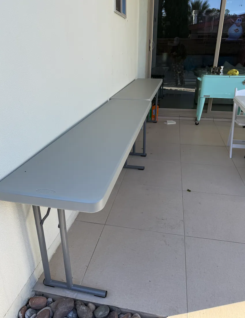 A round banquet table with a crisp white finish, elegantly set for six guests, placed in a sunlit event space with minimalistic decor.