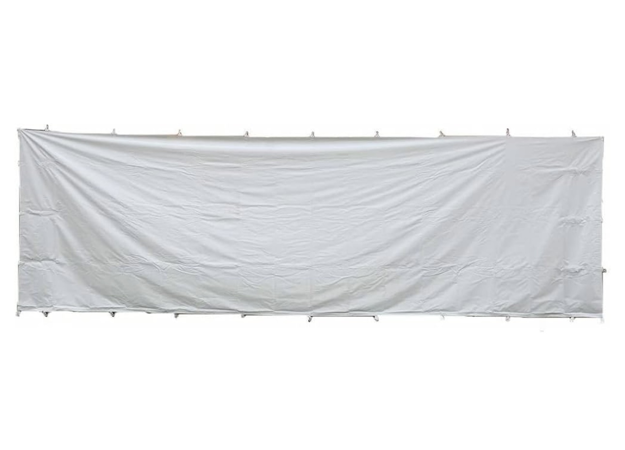 A 10x15 canopy tent providing shade for a family picnic in a city park, with picnic tables, children playing nearby, and colorful decorations hanging from the tent frame.