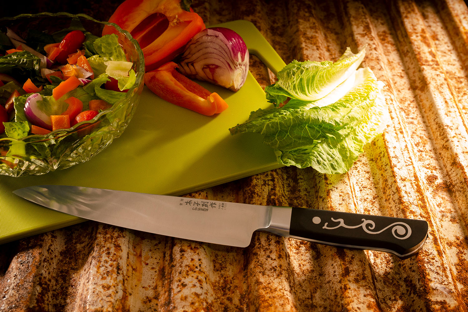 Commercial product photography of chef knife and fresh vegetables in a kitchen setting