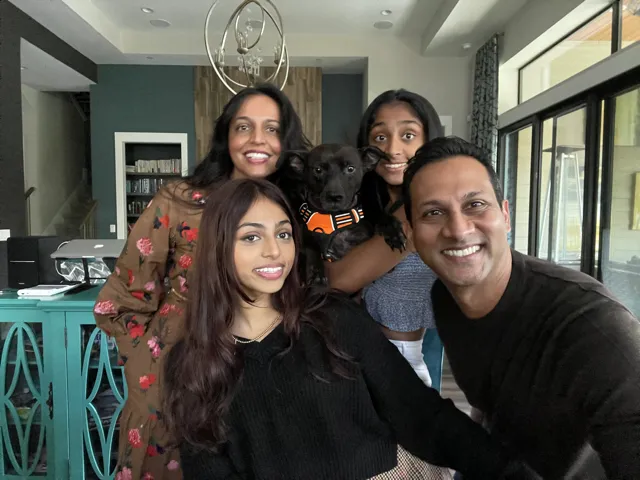 A smiling family poses with their rescue dog
