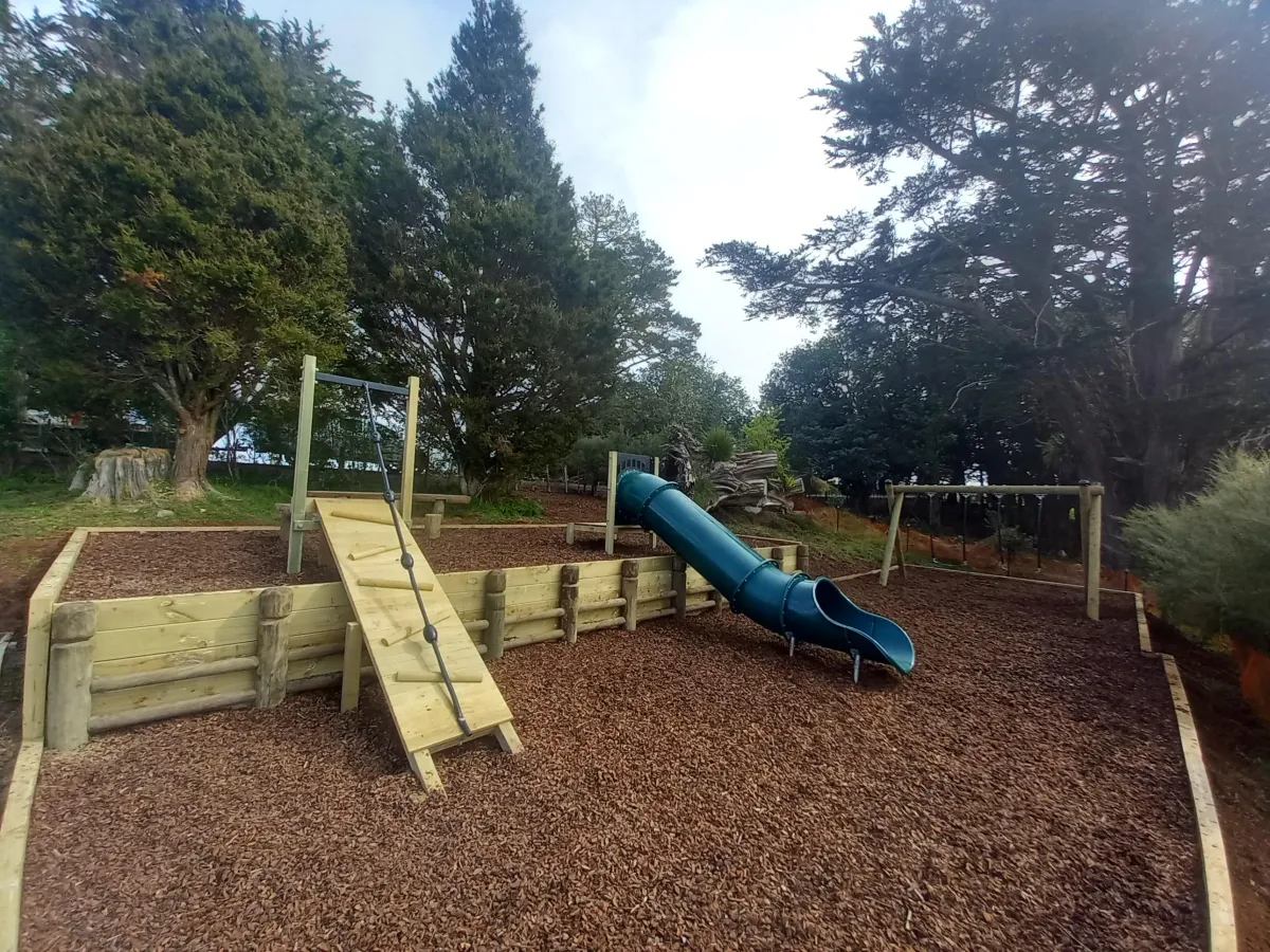 Timber playground with slide and mulch surfacing designed by Aspect Contracting