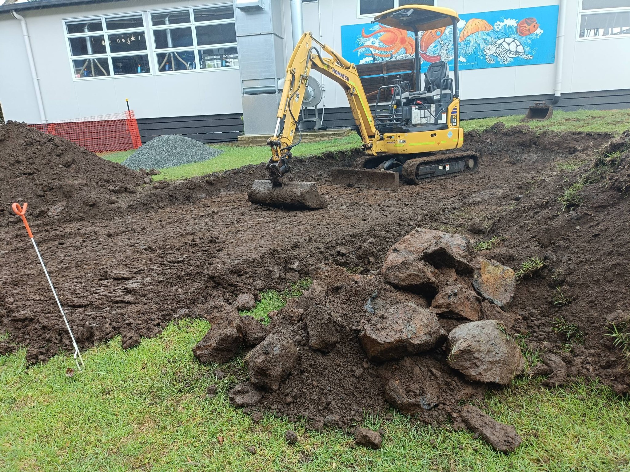 Mini excavator carrying out earthworks and rock removal on rural Northland site