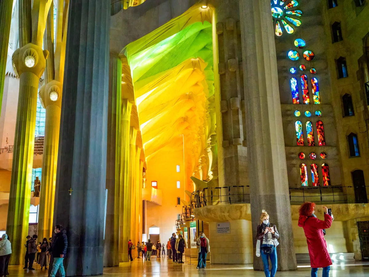 La Sagrada Familia cathedral with tall columns and yellow light streaming through the stained glass