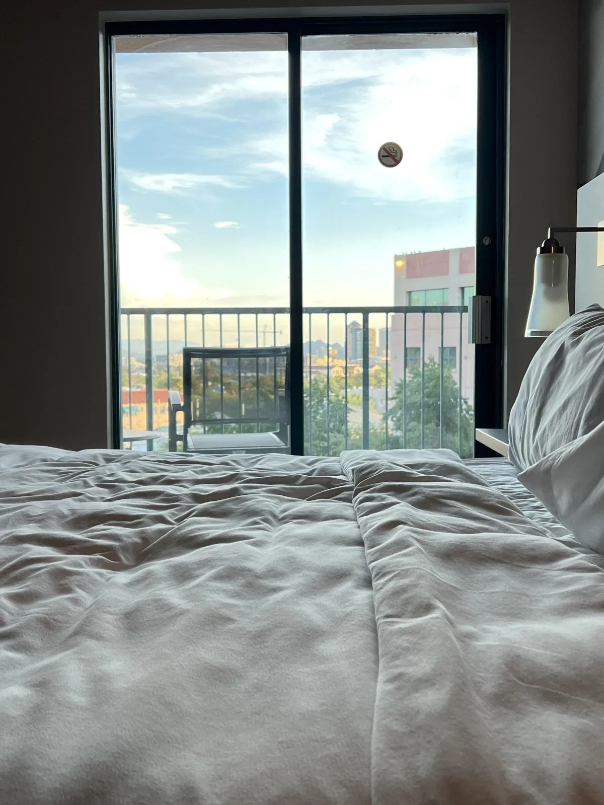 looking across a bed to sliding doors that lead to a balcony