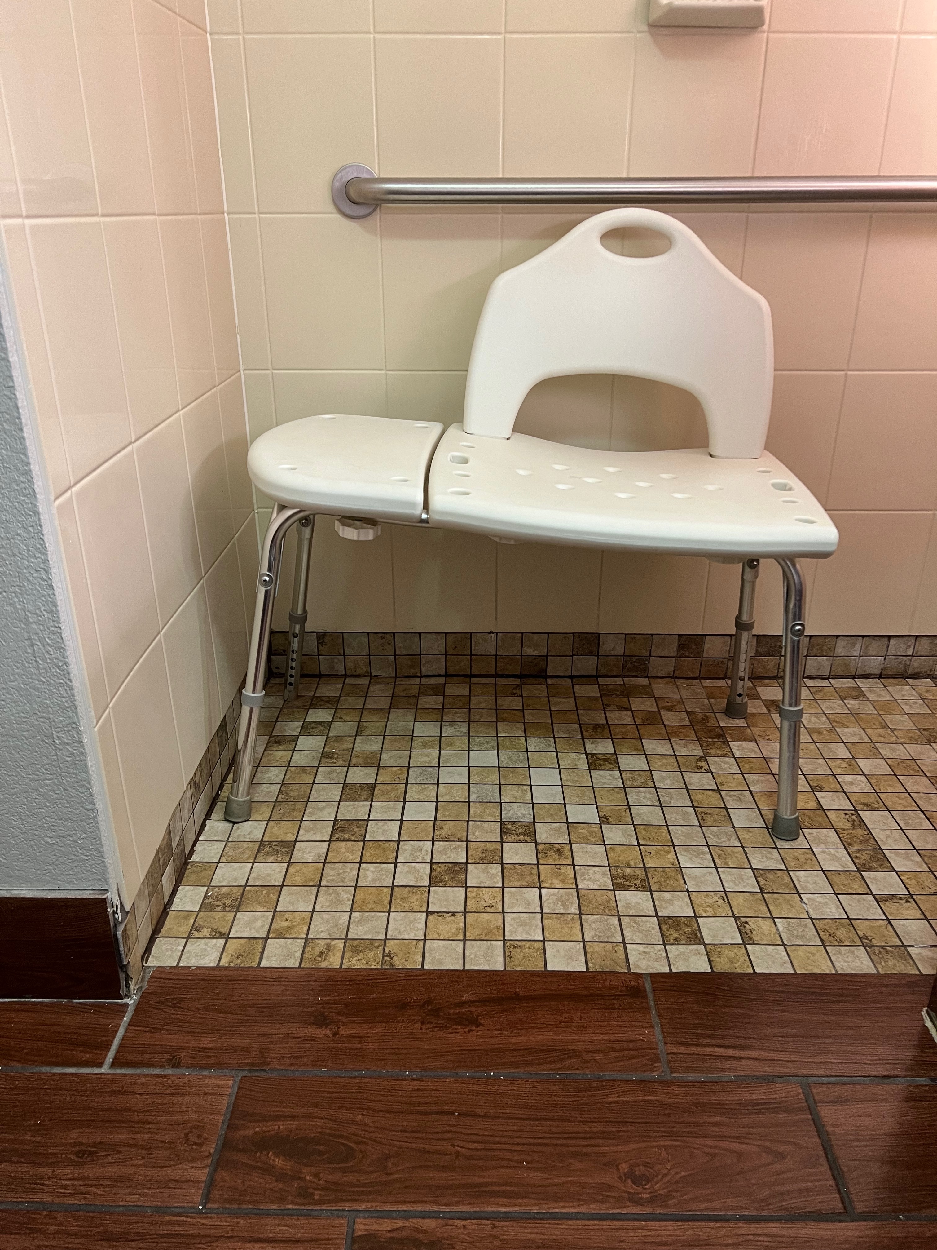 bathtub transfer bench sitting at skewed angle in tiled shower