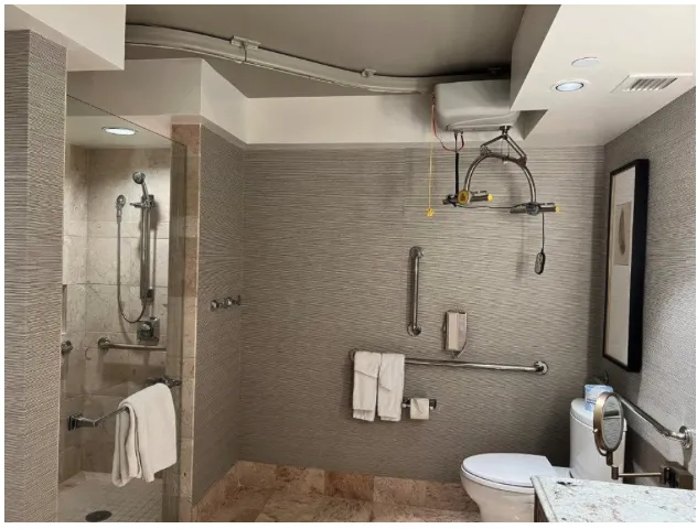 ceiling track going from toilet disappearing into entry door of shower in hotel bathroom