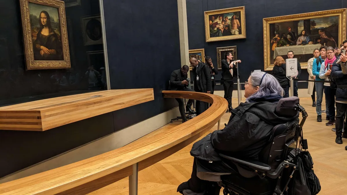 Heather looking at the Mona Lisa in the Louvre