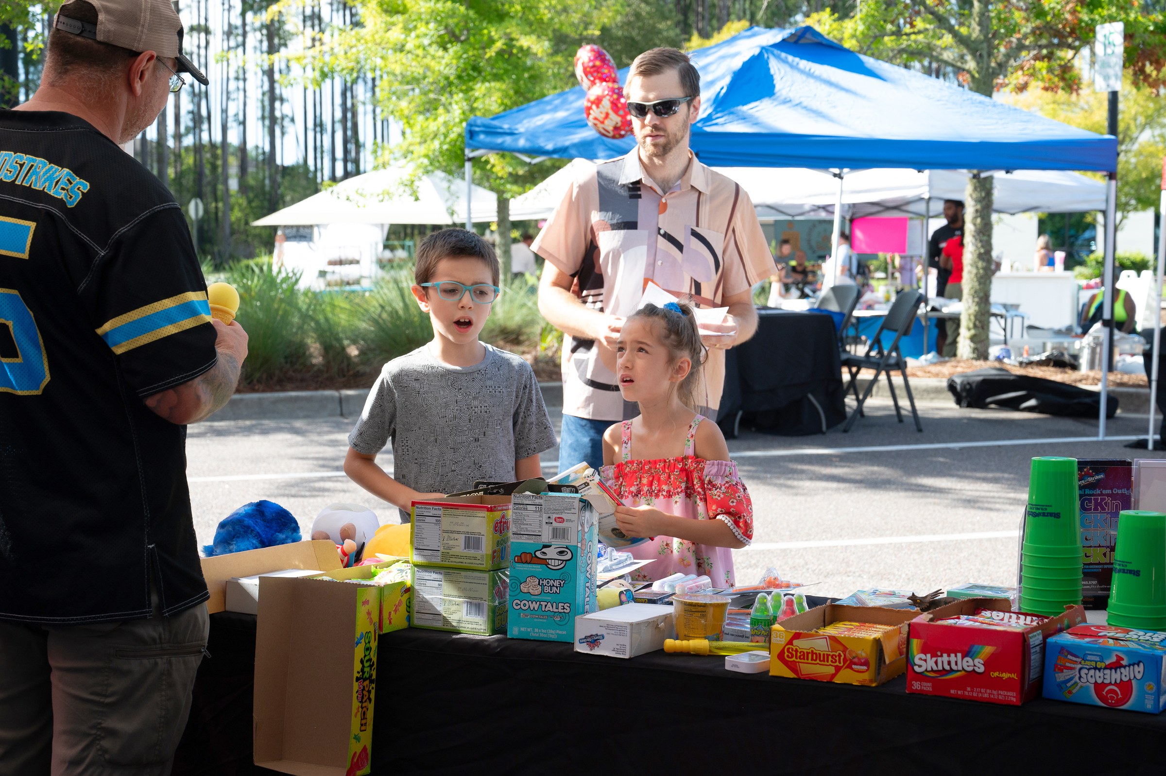 Kids picking prizes and treats at a partner activation table